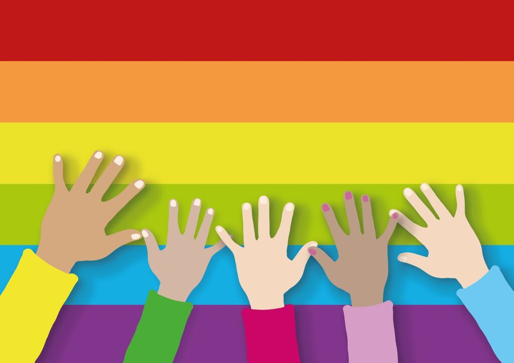 Diverse hands raised on rainbow flag